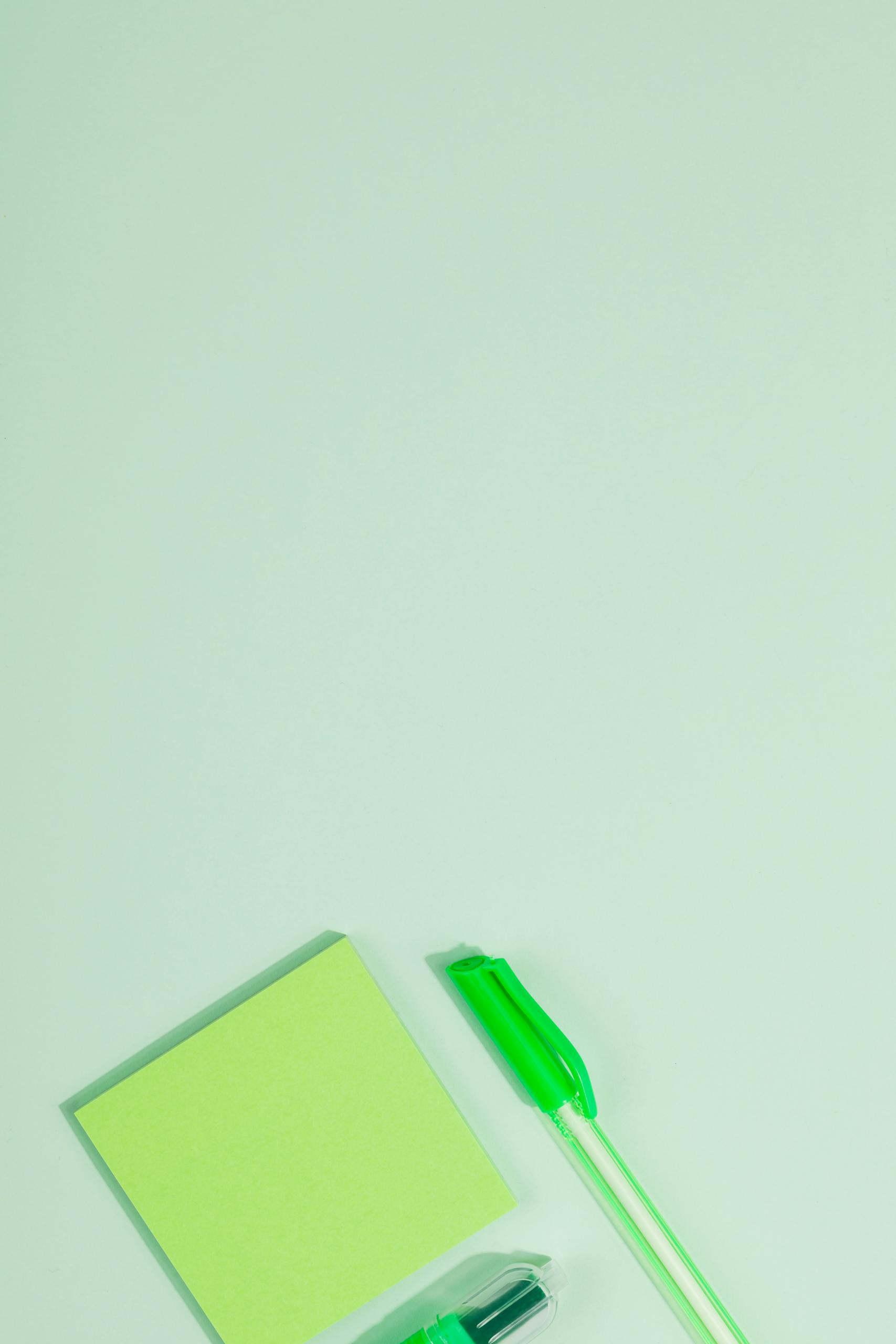 Top view of green office supplies on pastel green background, ideal for stationery themes.